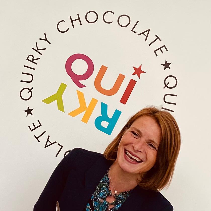 Justine in front of the Quirky Chocolate logo